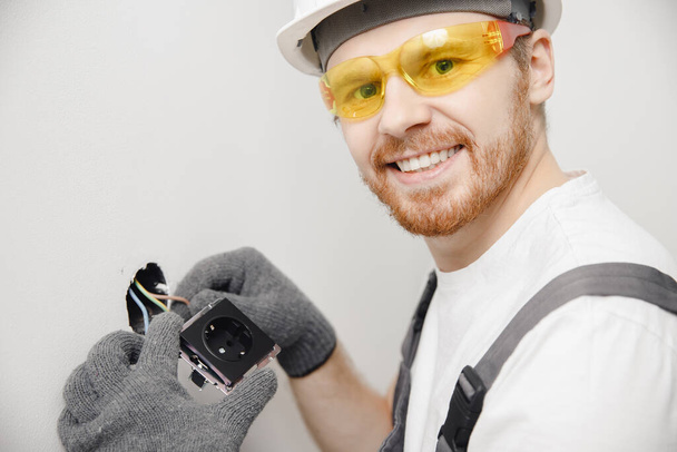 Electricista constructor de interruptores de trabajo y enchufes de sistema eléctrico residencial, color negro - Foto, imagen