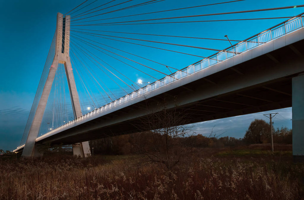 Cable-stayed most close-up ve večerních hodinách na pozadí modré oblohy a mraků - Fotografie, Obrázek