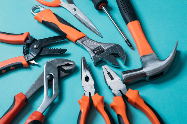 Gruppe von Werkzeugen mit orangen Griffen auf blauem Hintergrund - Foto, Bild