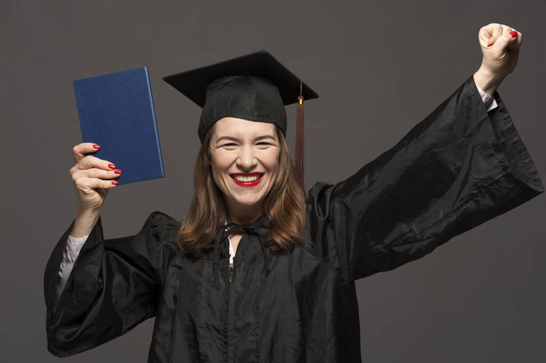 Graduate female student with stubble in eyeglasses wearing black mantle - Фото, зображення