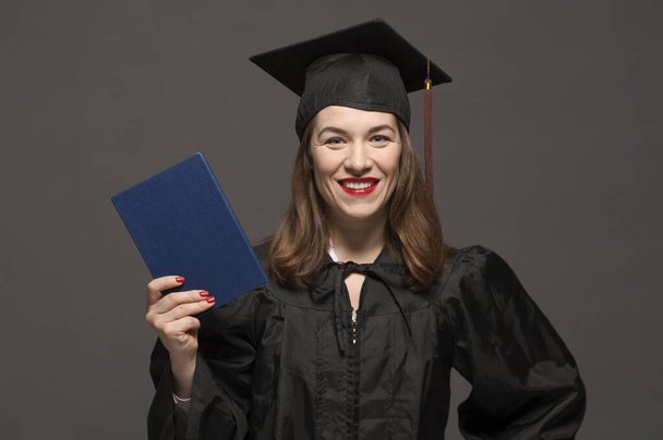 Graduate female student with stubble in eyeglasses wearing black mantle - Foto, imagen
