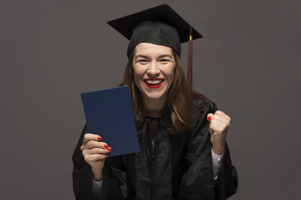 Graduate female student with stubble in eyeglasses wearing black mantle - Photo, Image