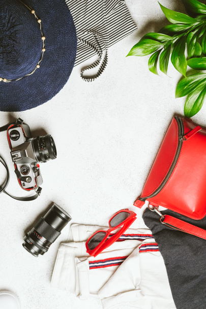 Set of women's clothing and accessories for summer holidays travel in red, blue and white colors. Travel vacation concept. Summer background. Top view copy space. - 写真・画像