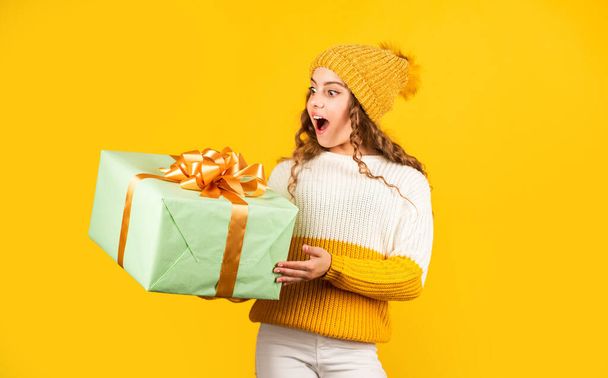 Birthday girl. Happy holidays. Xmas gift shopping. Gift package. Cherished dreams. Boxing day. Teen girl hold gift box. Kid hold present box yellow background. Purchase and delivery. Shopping mall - 写真・画像