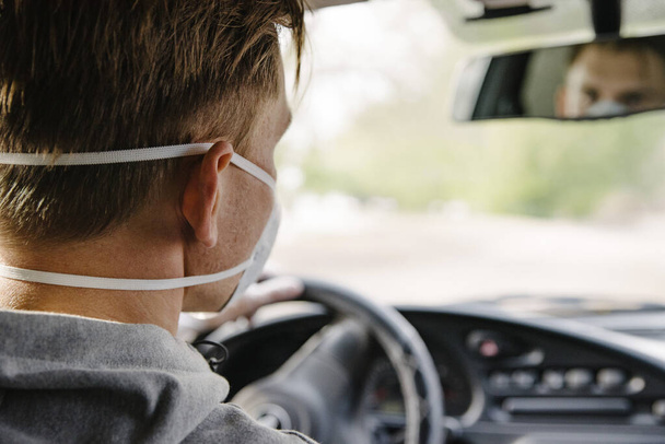 A man driving a car in a protective mask and gloves.Prevention of coronavirus infection.Protective measures against coronavirus, covid-19 - Fotoğraf, Görsel