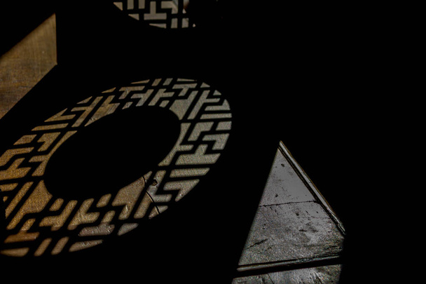 jeu de lumière et d'ombres à travers une boîte à gâteau au thé puerh
 - Photo, image