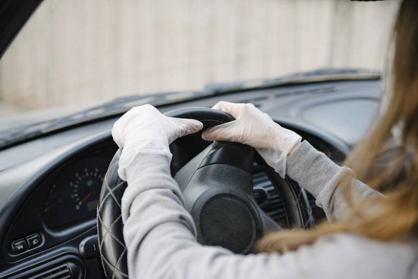 Female driver in a mask and gloves holding the steering wheel, close-up.Prevention of coronavirus infection.Protective measures against coronavirus, covid-19 - Foto, immagini