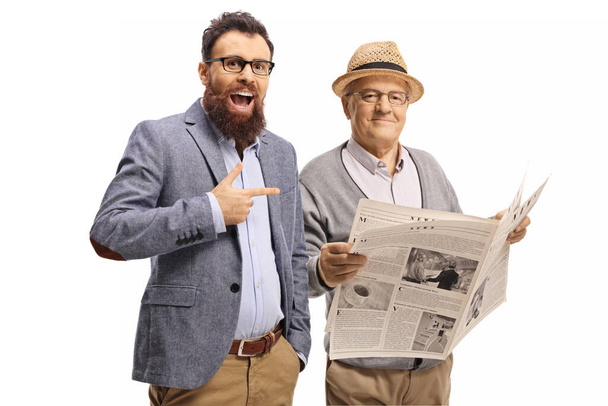 Bearded man laughing and pointing at an elderly man with a newspaper isolated on white background - Photo, Image