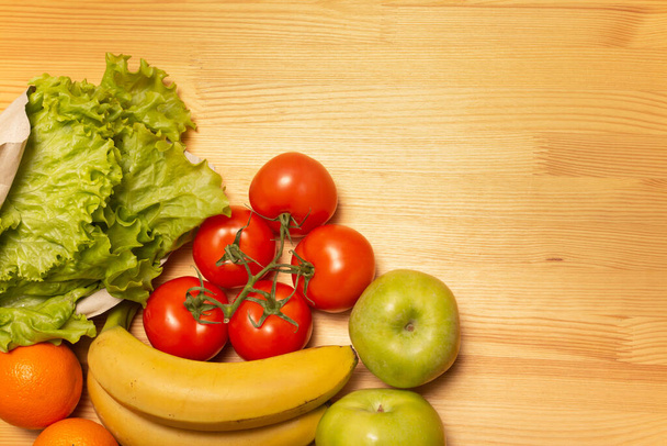 Ruoankuljetuspalvelu. Terveellistä ruokaa puupöydällä. Osta verkossa karanteenin aikana. Tomaatteja, omenoita, banaaneja, appelsiineja, salaattia. Laadukas kuva. Pysy kotona, ole turvassa.
. - Valokuva, kuva