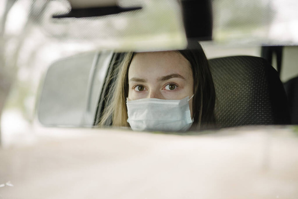 A woman driving a car in a protective mask and gloves.Prevention of coronavirus infection.Protective measures against coronavirus, covid-19 - Foto, immagini