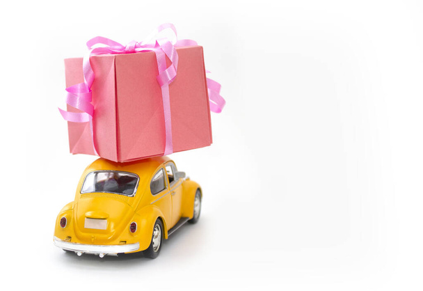 vintage toy car carries a box with a gift, a template with a place for text, isolated on a white background - Фото, изображение