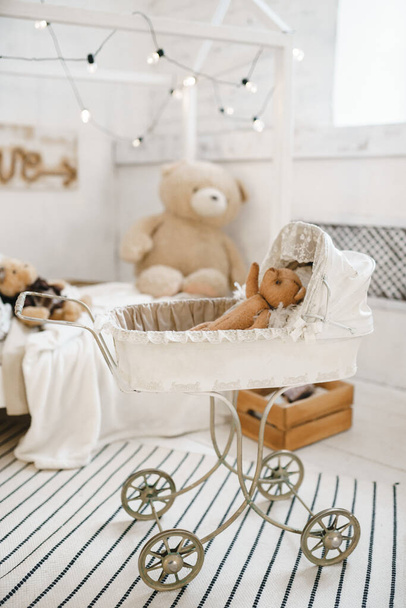 old teddy bears sitting in vintage baby carriage with toys - Photo, Image