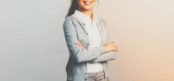 Education, women and lifestyle concept. Attractive asian female entrepreneur, girl tutor smiling satisfied, cross hands chest, pleased help customer with any question, grey background - Φωτογραφία, εικόνα