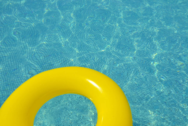 Colorful inflatable tube floating in a swimming pool, summer vacation concept - Photo, Image