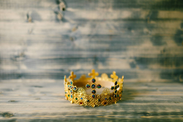 Золотая корона, инкрустированная драгоценными камнями для свадьбы в церкви
 - Фото, изображение