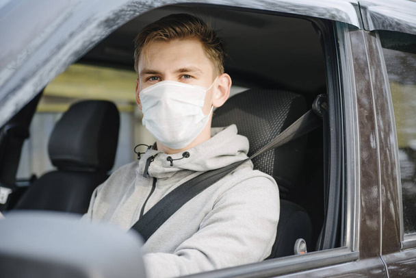 A man driving a car in a protective mask and gloves.Prevention of coronavirus infection.Protective measures against coronavirus, covid-19 - Foto, Imagem