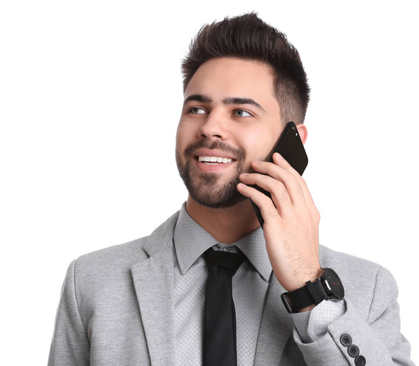 Young businessman talking on smartphone against white background - Фото, зображення