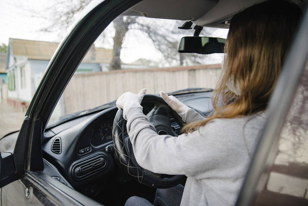 A woman driving a car in a protective mask and gloves.Prevention of coronavirus infection.Protective measures against coronavirus, covid-19 - Valokuva, kuva