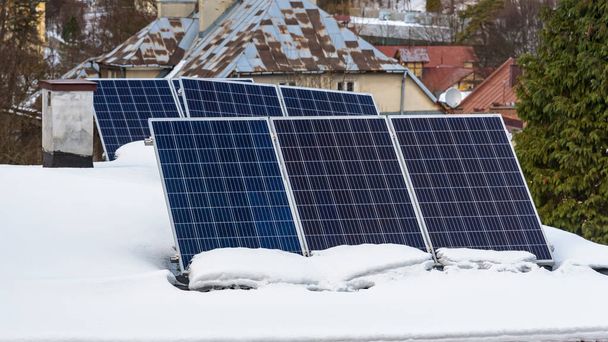 Panele słoneczne elektrowni fotowoltaicznej na dachu pokrytym śniegiem - Zdjęcie, obraz