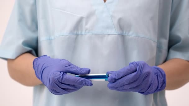 Epidemiologi pitää testin koronavirus covid 19. Käsi steriileissä käsineissä.
. - Materiaali, video