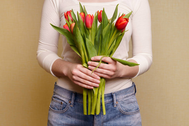 Young Woman holding bouquet of tulips in her hands  - Fotografie, Obrázek
