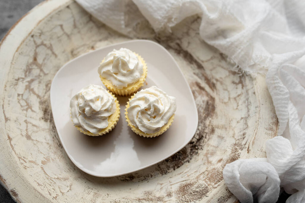 Three mini Cheesecakes with whipped cream icing on a white plate - Photo, Image