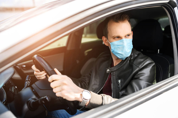 Young man in protective mask is driving car - Foto, immagini