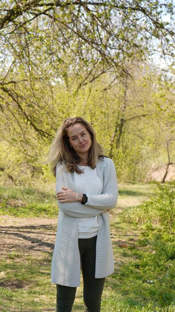 Porträt einer stilvollen attraktiven Frau mit langen Haaren auf Wegen in einem Frühlingspark. Reifes Schönheitskonzept - Foto, Bild