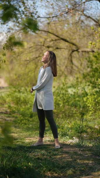 Egy elegáns, vonzó nő portréja, hosszú hajjal az ösvényeken egy tavaszi parkban. Érett szépség fogalma - Fotó, kép