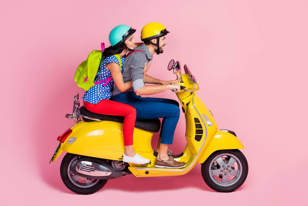Profile side view of his he her she nice attractive cheerful cheery couple driving moped pastime having fun vacation adventure isolated over pink pastel color background - 写真・画像