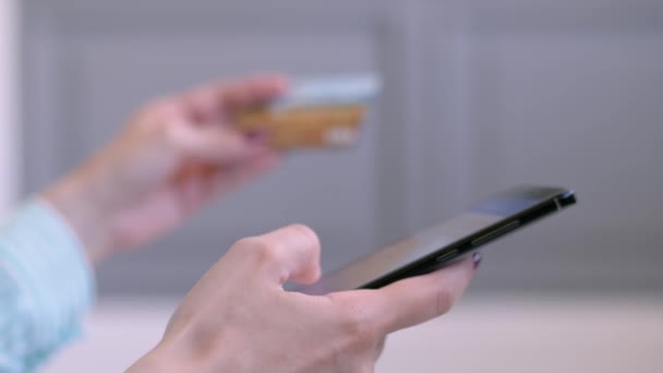 Žena pomocí smartphone a kreditní karty pro on-line nakupování - zblízka boční pohled - Záběry, video