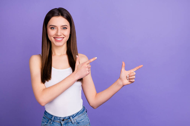 Portrait of positive cheerful girl promoter point index finger copyspace indicate advert promotion recommend suggest select wear good look singlet isolated over purple color background - Foto, imagen