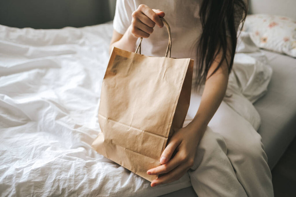 Woman holds craft eco shopping bag in hands. - Foto, afbeelding