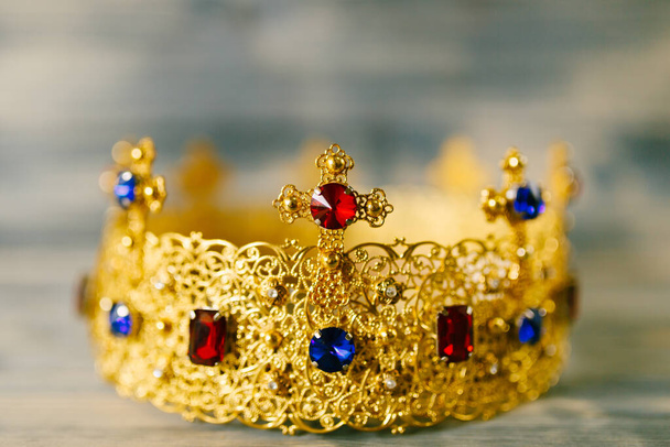 Золотая корона, инкрустированная драгоценными камнями для свадьбы в церкви
 - Фото, изображение
