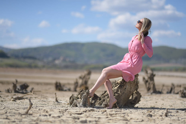 woman in pink dress walking in a desert - Photo, Image