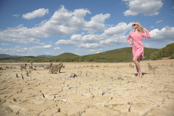 γυναίκα σε ροζ φόρεμα περπατώντας σε μια έρημο - Φωτογραφία, εικόνα