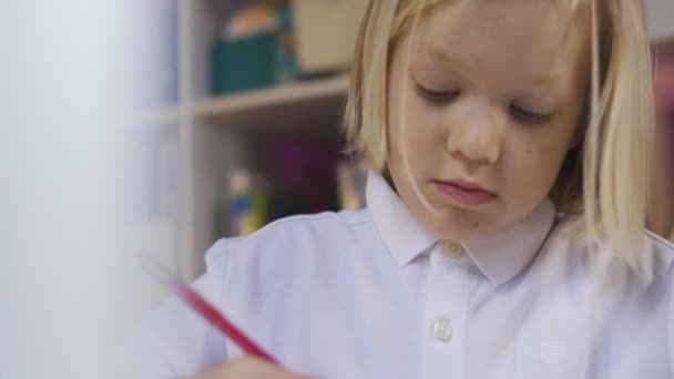 Distance learning online education. Portrait of a Cute school boy drawing in a childrens room - Felvétel, videó