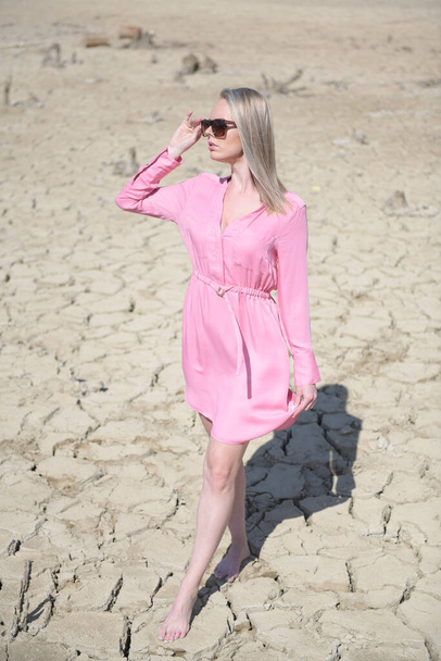 mujer en vestido rosa caminando en un desierto
 - Foto, imagen