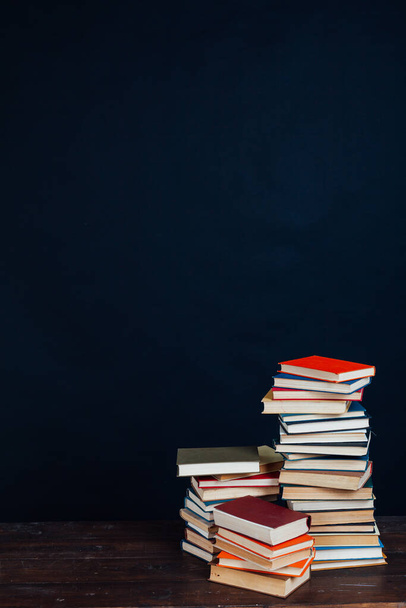 many stacks of educational books in the university library on a black background - Zdjęcie, obraz