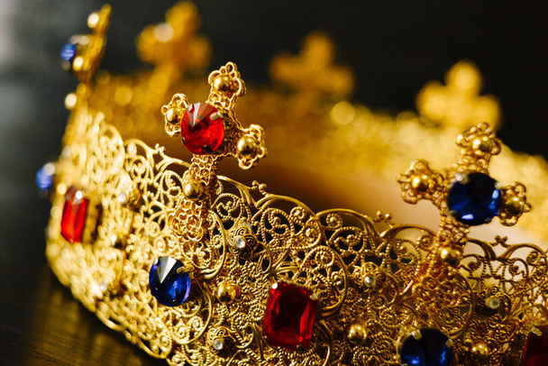 Golden crown encrusted with blue and red gemstones - Фото, изображение