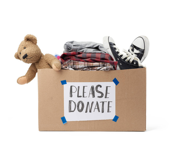 boîte en carton marron avec une feuille blanche collée et l'inscription s'il vous plaît faire un don sur un fond blanc, vêtements intérieurs, jouets, concept d'aide
 - Photo, image