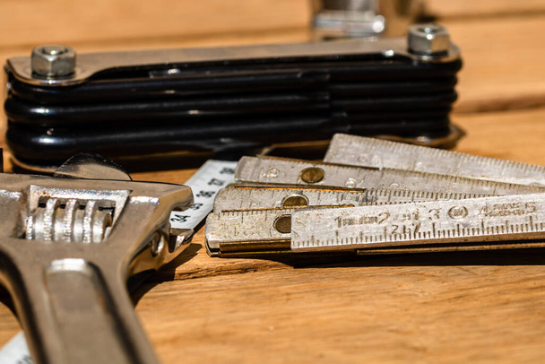 Εργαλεία για επισκευές και κατασκευές. Hummer, ρυθμιζόμενο κλειδί, χάρακα. Όργανα σε ρουστίκ ξύλινο τραπέζι με χώρο αντιγραφής - Φωτογραφία, εικόνα