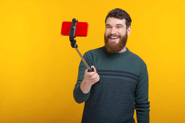весёлый улыбающийся мужчина с бородой снимает видеоблог для социальных сетей
 - Фото, изображение