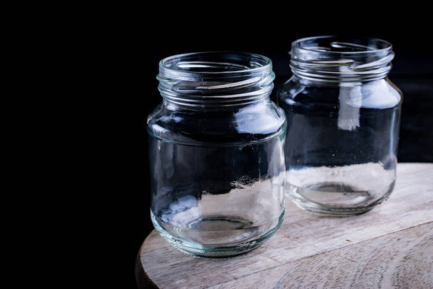 Concetto di riciclaggio. Due vasi di vetro riutilizzabili su un legno
. - Foto, immagini