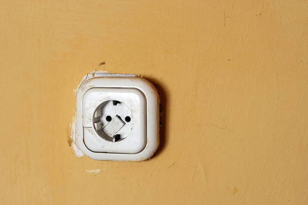 Dirty power outlet on a yellow wall. - Photo, Image