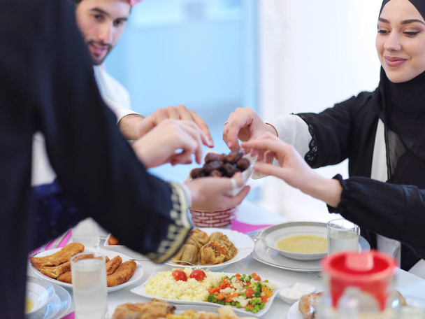 Eid Mubarak Muslim family having Iftar dinner eating dates to break feast. Eating traditional food during Ramadan feasting month at home. The Islamic Halal Eating and Drinking at modern western Islam - Foto, Bild