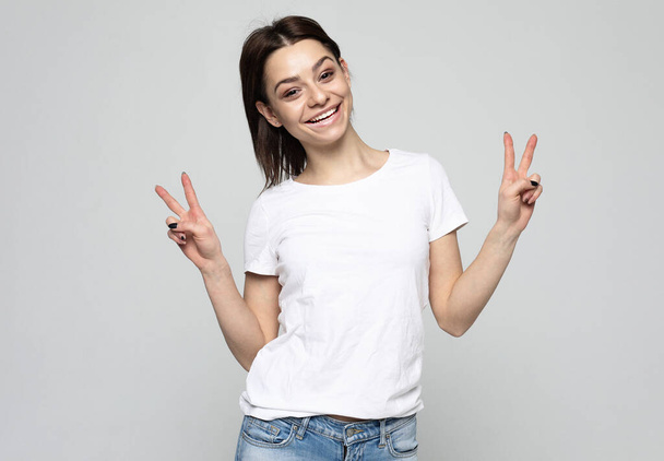 lifestyle and people concept: lovely woman showing victory or peace sign - Foto, immagini
