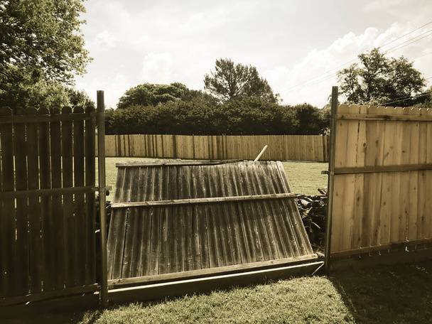 Gefilterde afbeelding ingeklapt houten hek in de buurt van nieuwe timmerhout platen installatie van buitenwijken woonhuis - Foto, afbeelding