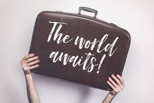 The world awaits message on a vintage travel suitcase - Fotografie, Obrázek