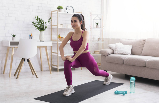 Quédate en casa, mantente activo. Chica latina haciendo ejercicio cardiovascular en la sala de estar
 - Foto, Imagen